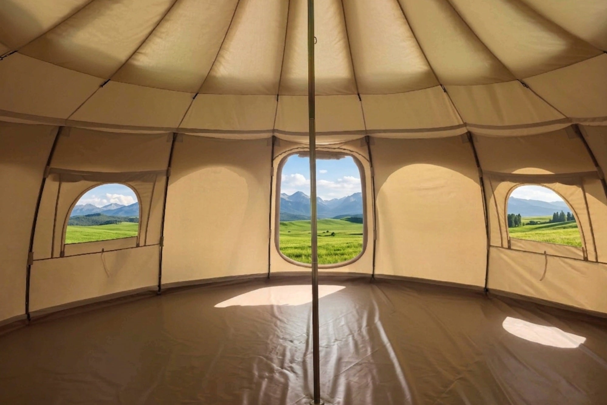 20ft Better Bell tent interior with central pole, panoramic windows, and scenic mountain and green field views in daylight